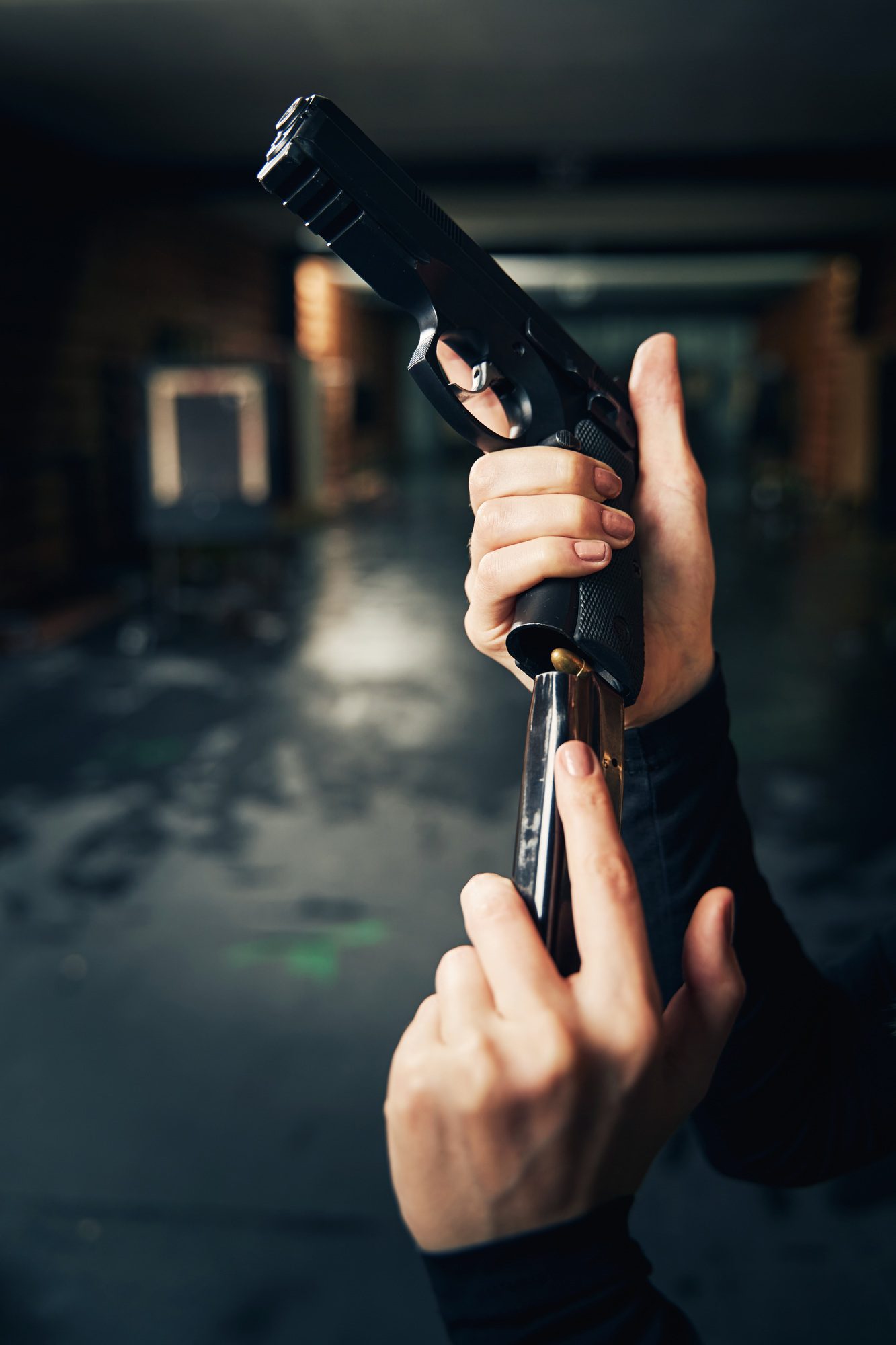 Woman military loading a pistol before a shooting drill